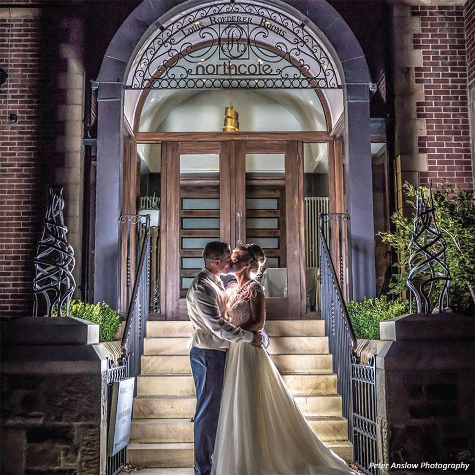 Bride and groom in front of Northcote