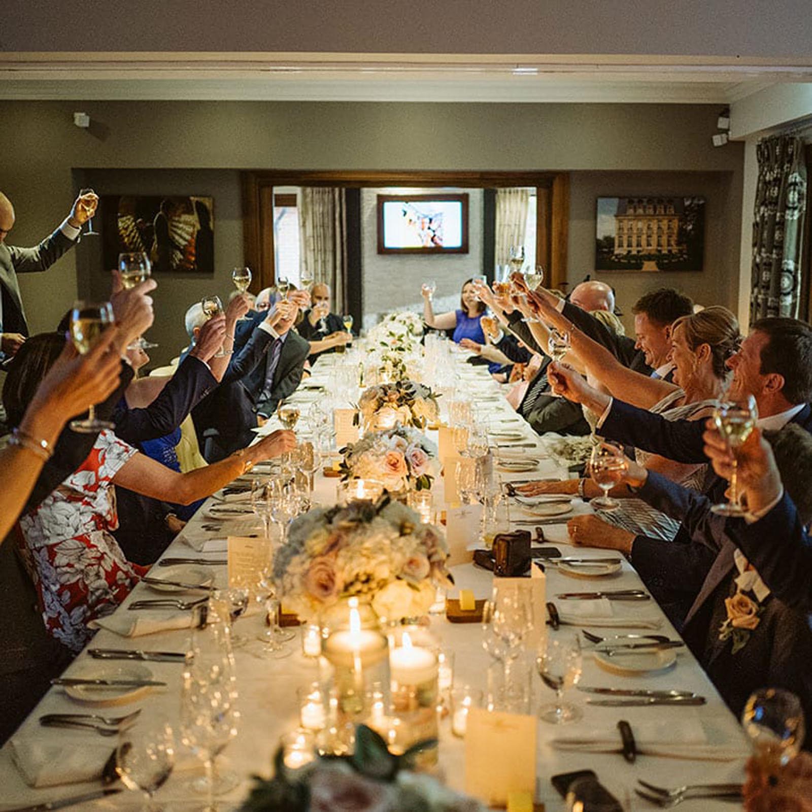 Guests all raising a glass in the private dining room.