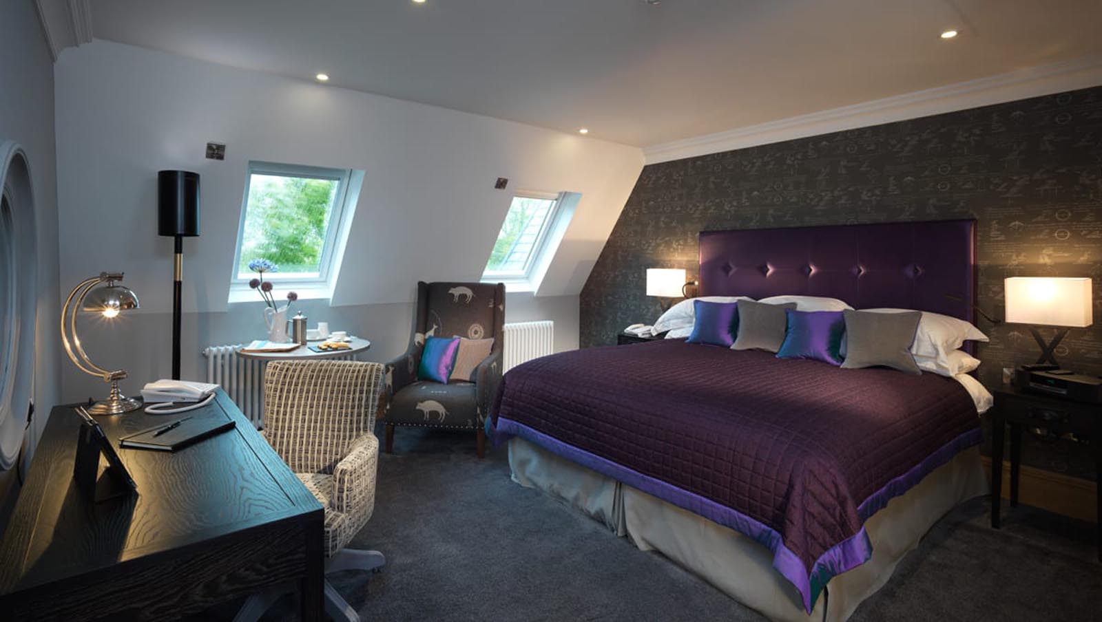 One of our classic rooms with a large double bed, seating area and desk