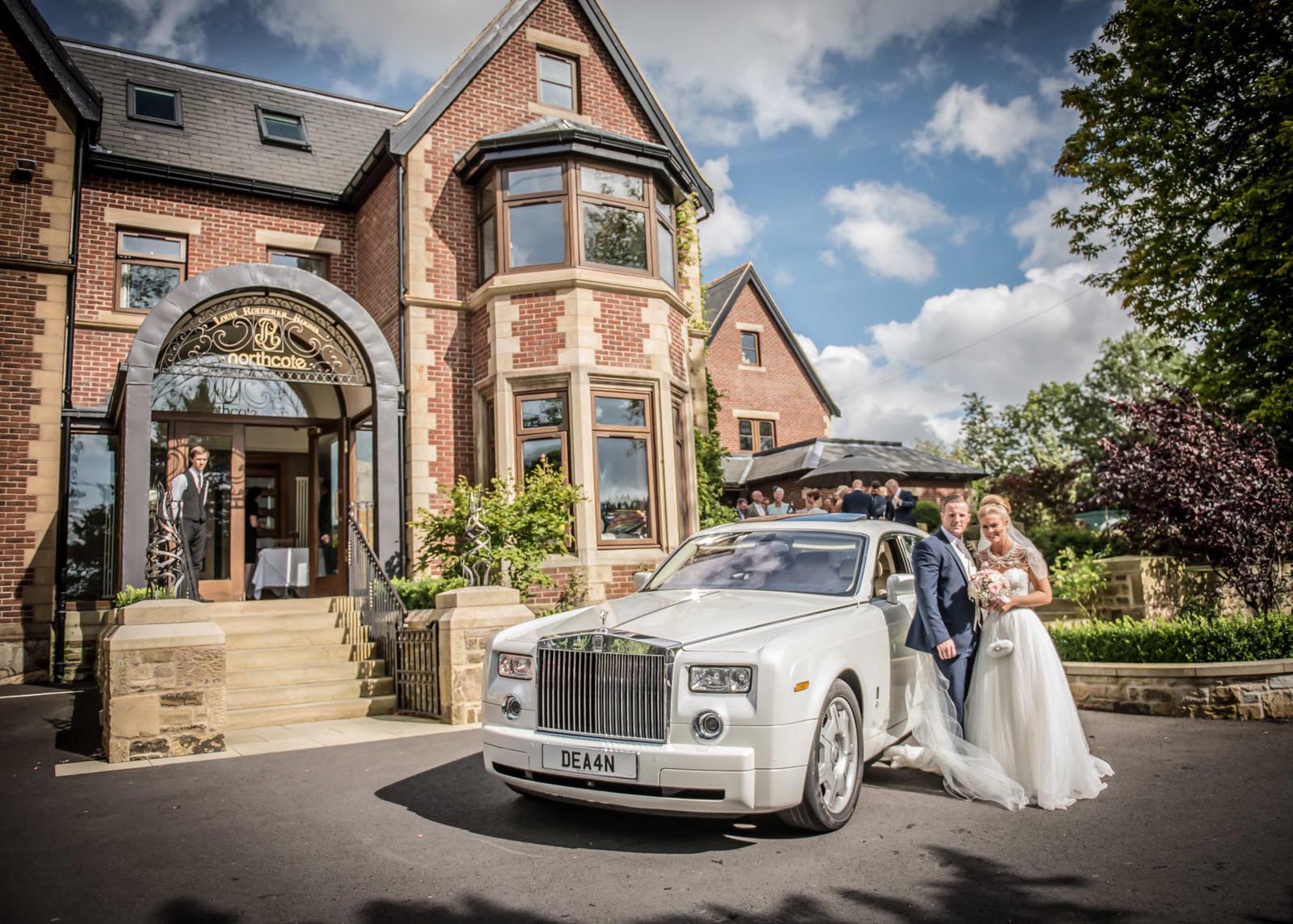 Bride and groom with their wedding car in front of Northcote